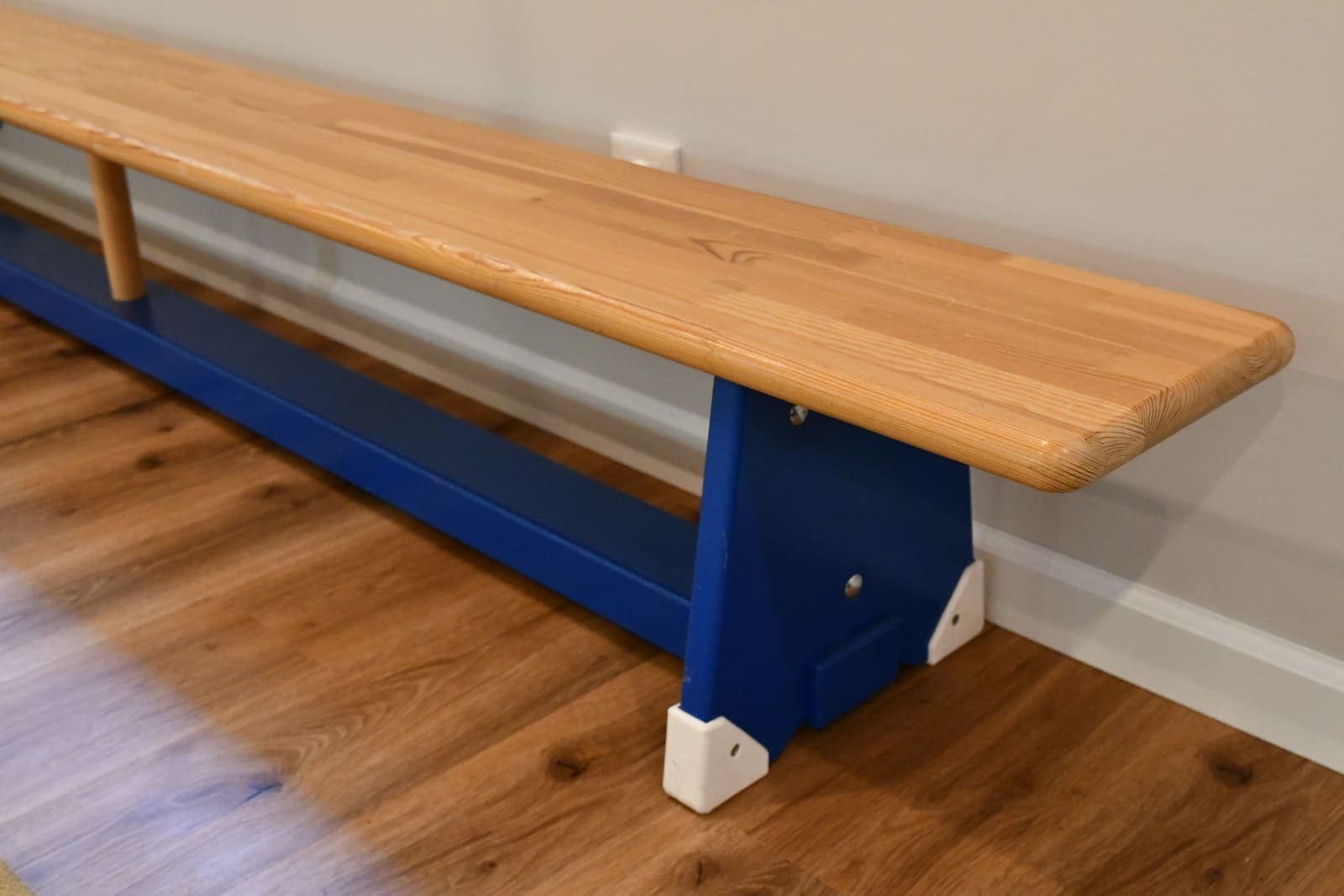 Langbank aus hellem Holz auf dem Parkett