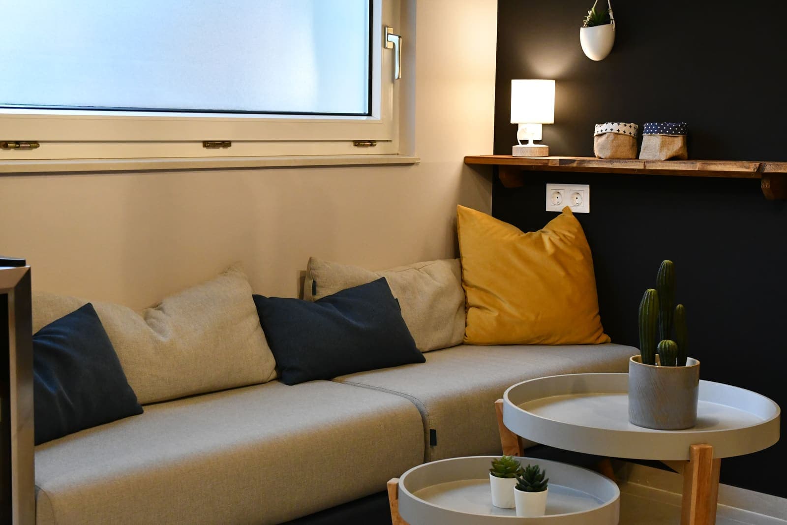Lounge-Ecke mit Sofa, Pölstern und Beistelltischen